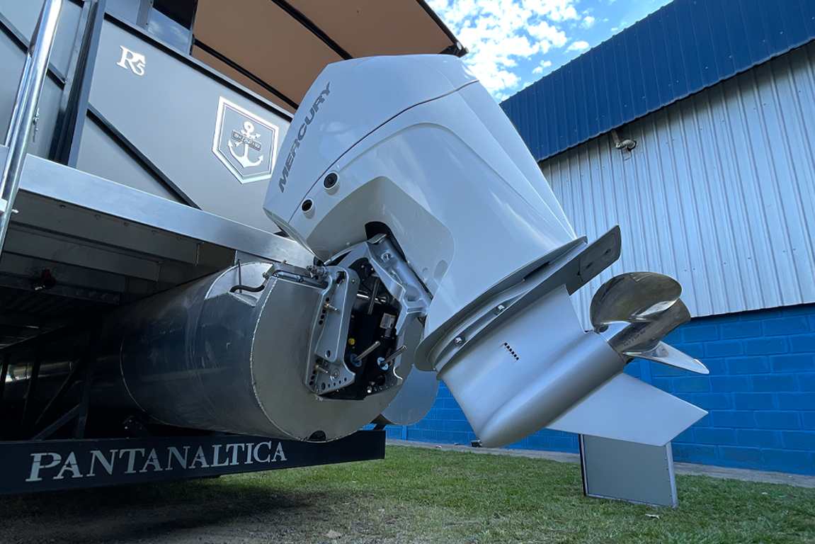 Detalhe em close-up de um motor de popa Mercury branco instalado na traseira de um barco de alumínio